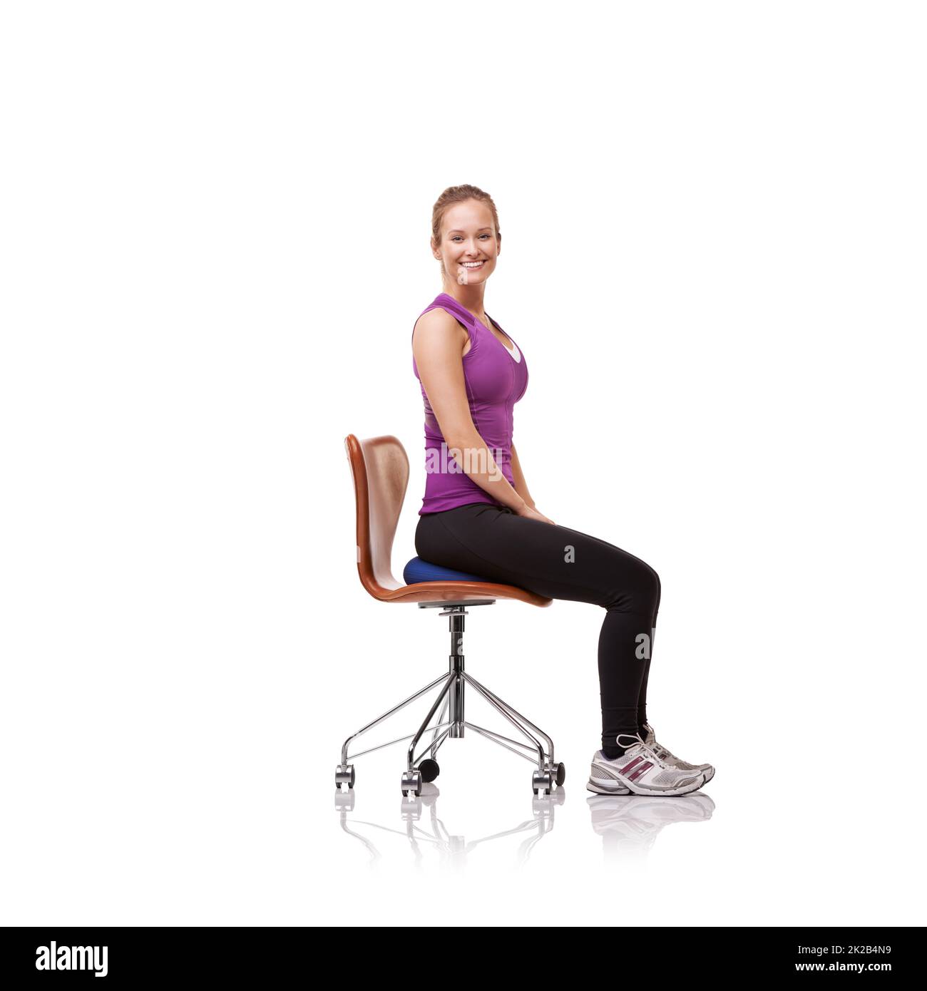 Perfecto para tu postura. Fotografía de una mujer deportiva que se estira en una silla. Foto de stock