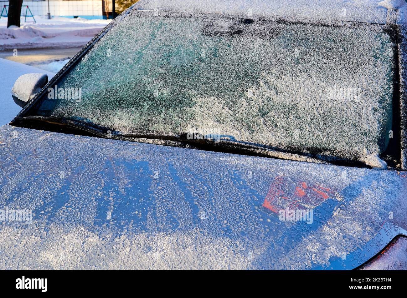 El parabrisas cubierto de escarcha en el coche en un día de invierno al sol Foto de stock
