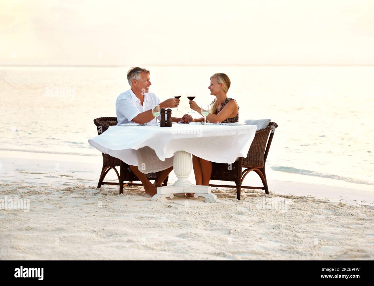 Pareja de mediana edad disfrutando de una cena romántica en la playa. Foto de una pareja adulta disfrutando de una cena romántica en la playa. Foto de stock