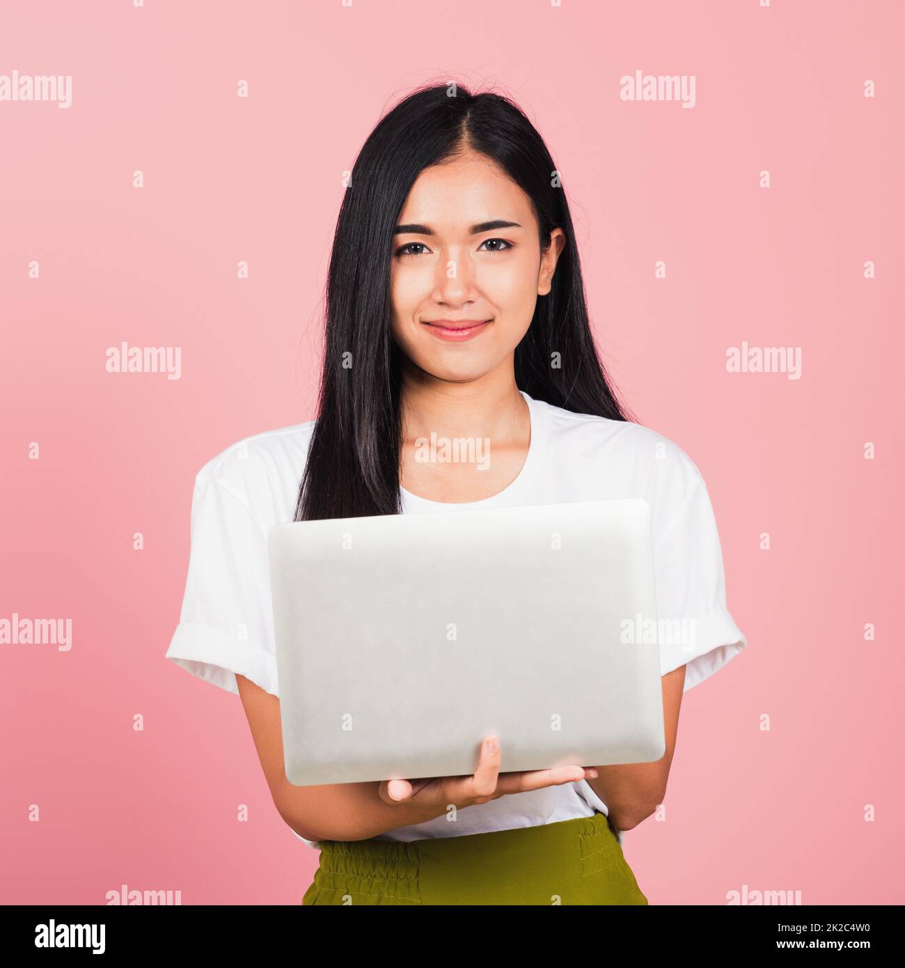 mujer confidente sonriente cara sosteniendo usando computadora portátil Foto de stock