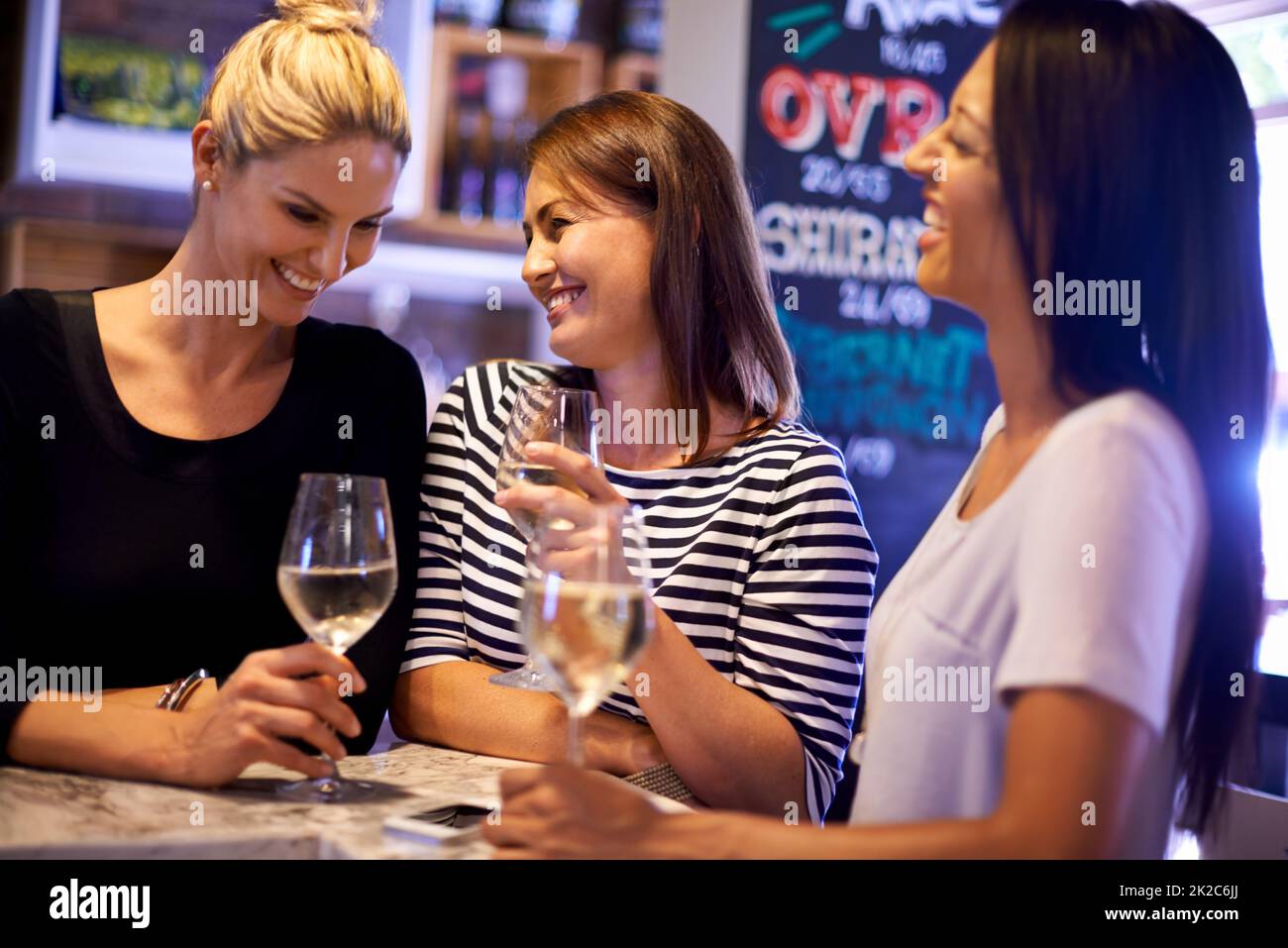 Noche de chicas. Una foto recortada de tres mujeres socializando en un restaurante. Foto de stock