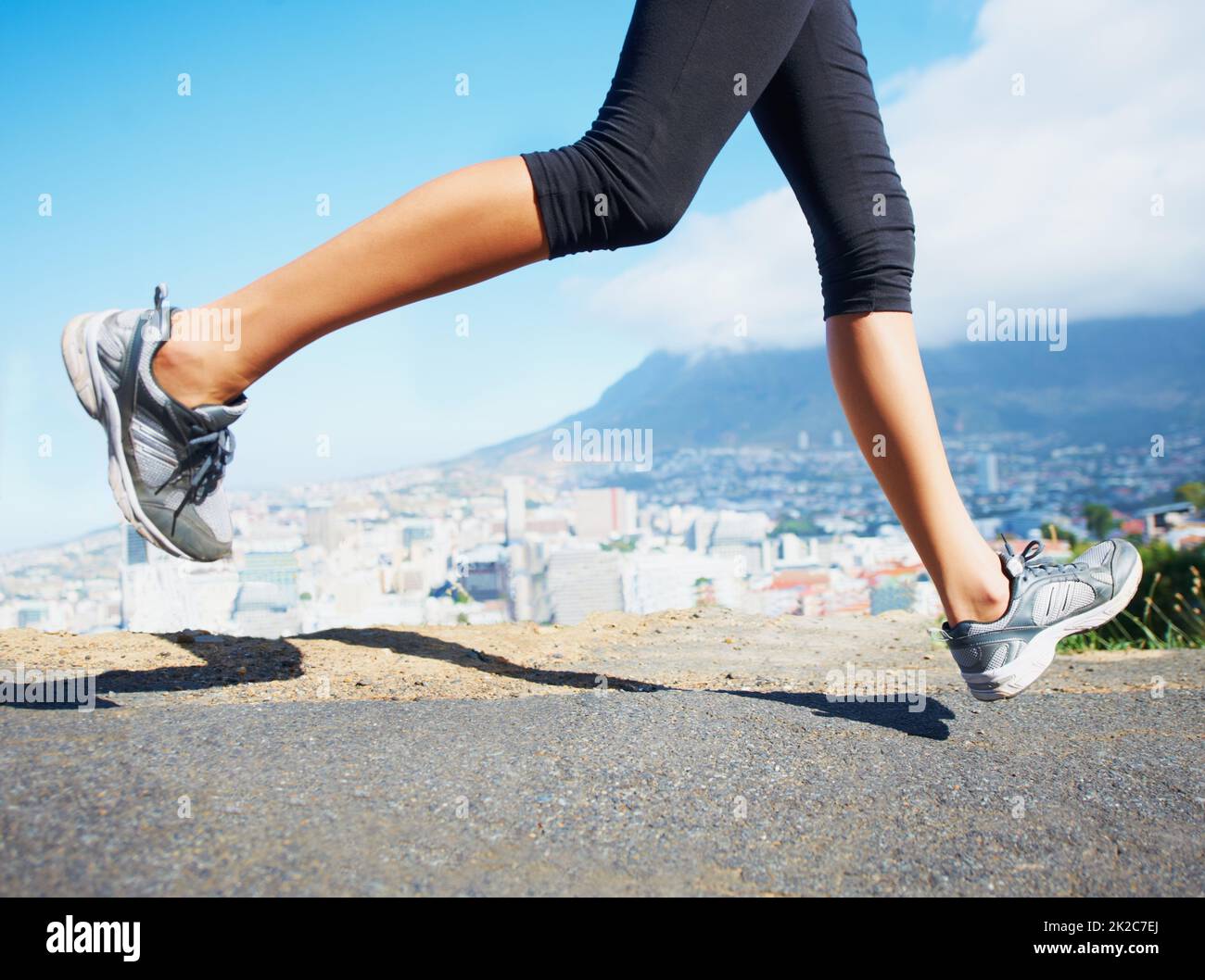 Corredor de carretera. Fotografía recortada de una mujer deportiva que va a correr al aire libre. Foto de stock