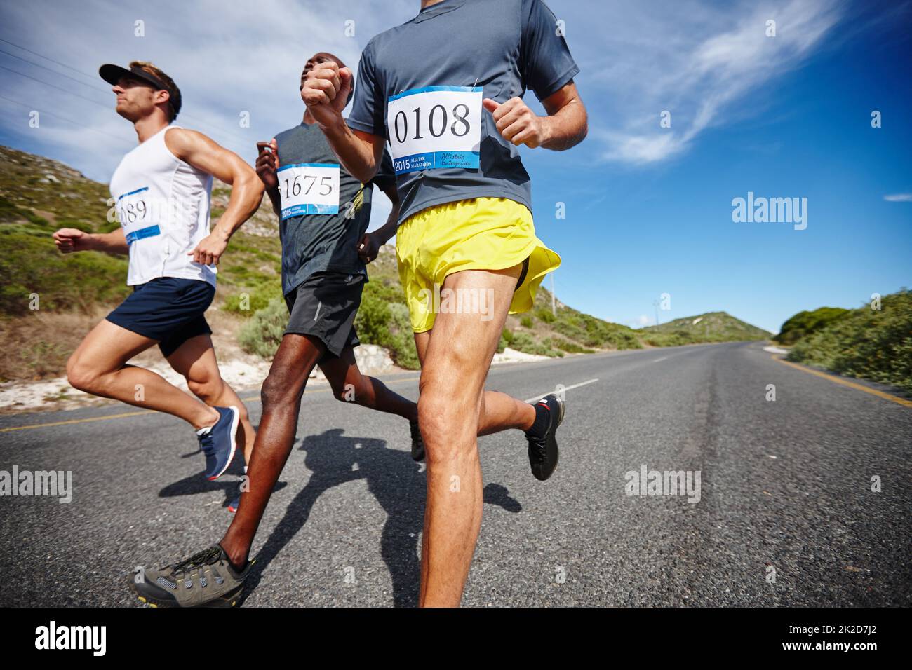 Competir con los mejores. Tiro de un grupo de hombres corriendo una carrera de carretera. Foto de stock