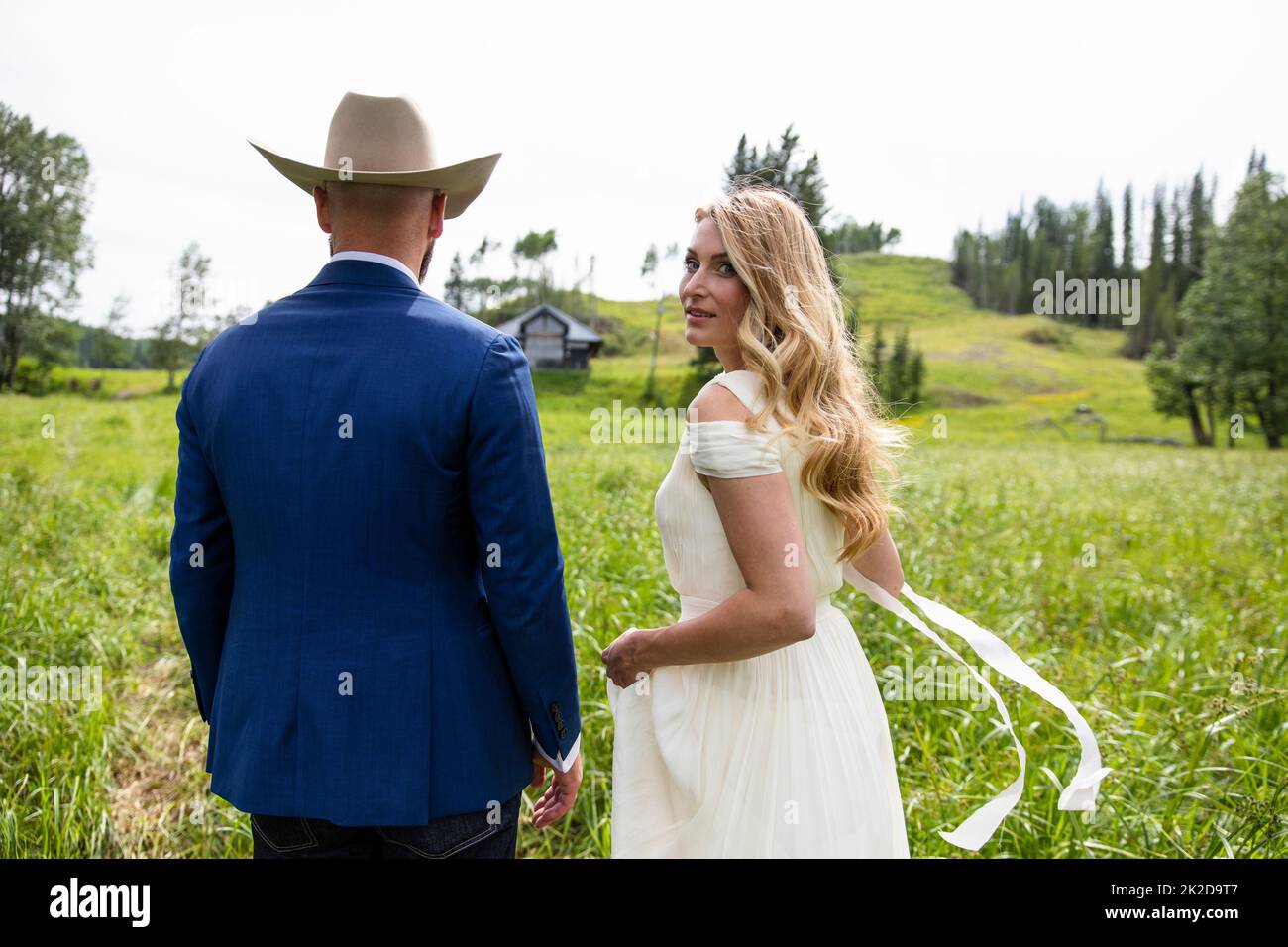 Retrato de la novia y el novio en sombrero de vaquero en el campo soleado el día de la boda Foto de stock