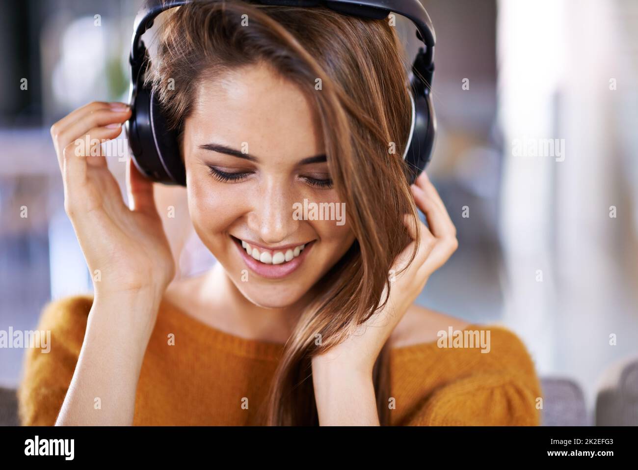 Escuchar algunos grandes ritmos. Hermosa mujer joven escuchando música en casa. Foto de stock