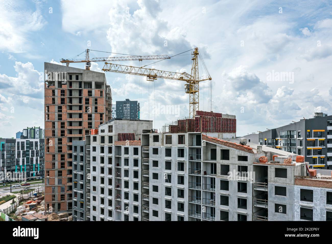 grúas y edificios residenciales en construcción sobre fondo azul celeste. obra de la ciudad. foto aérea. Foto de stock