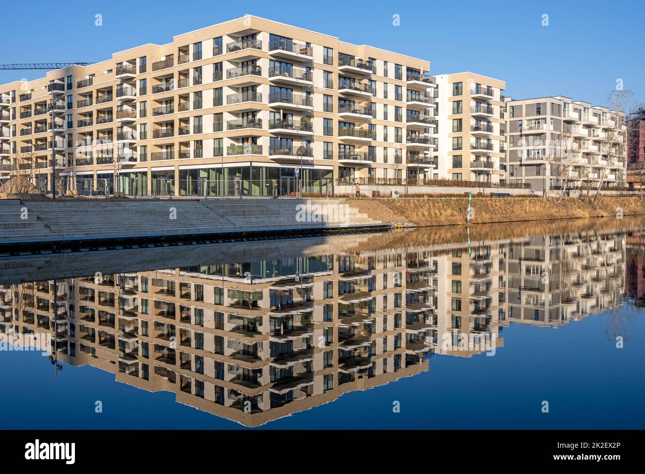 Modernos edificios de apartamentos que se reflejan en un canal visto en Berlín, Alemania Foto de stock