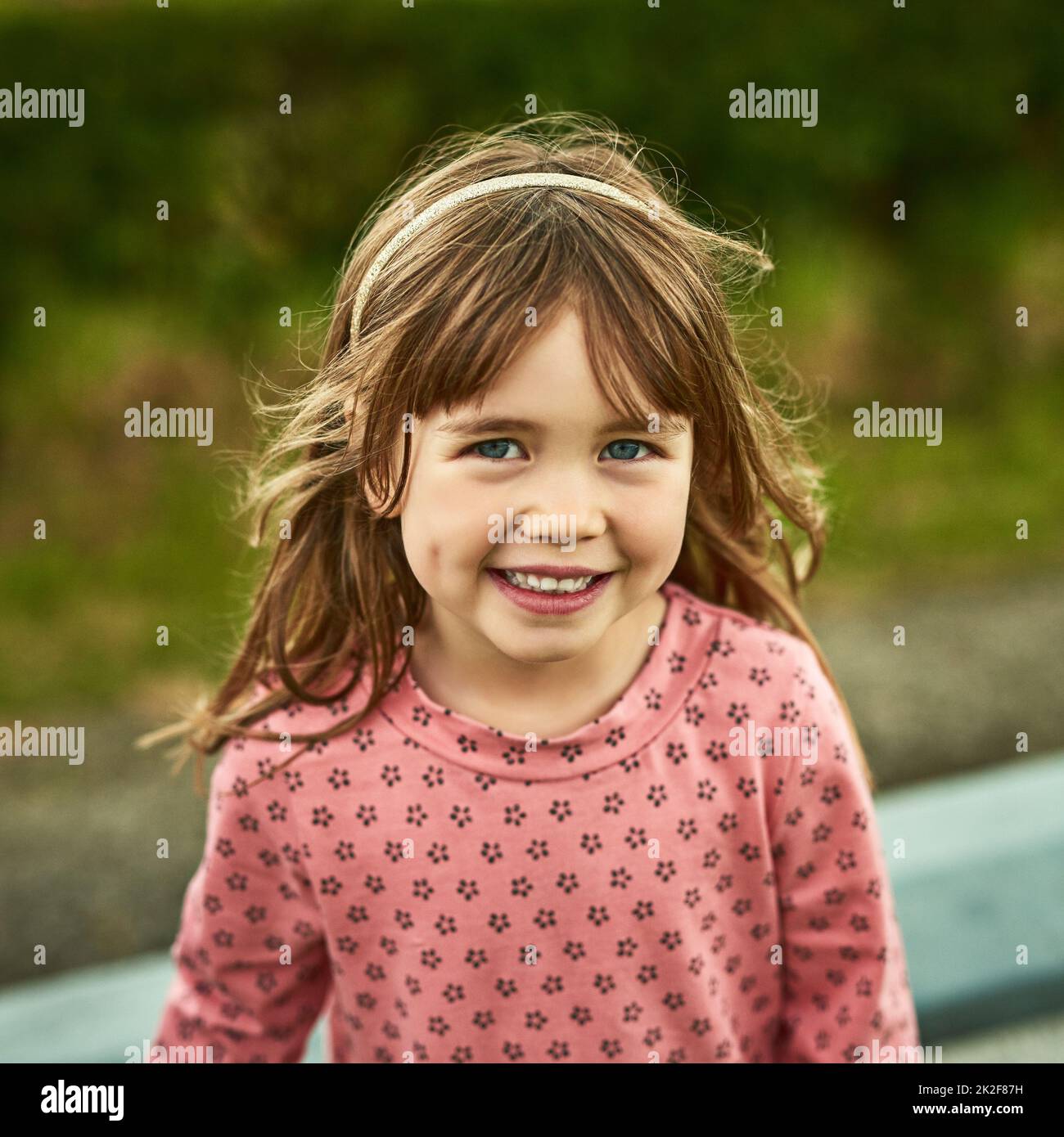 El mundo para los niños está lleno de diversión. Retrato de una adorable niña que se divierte al aire libre. Foto de stock