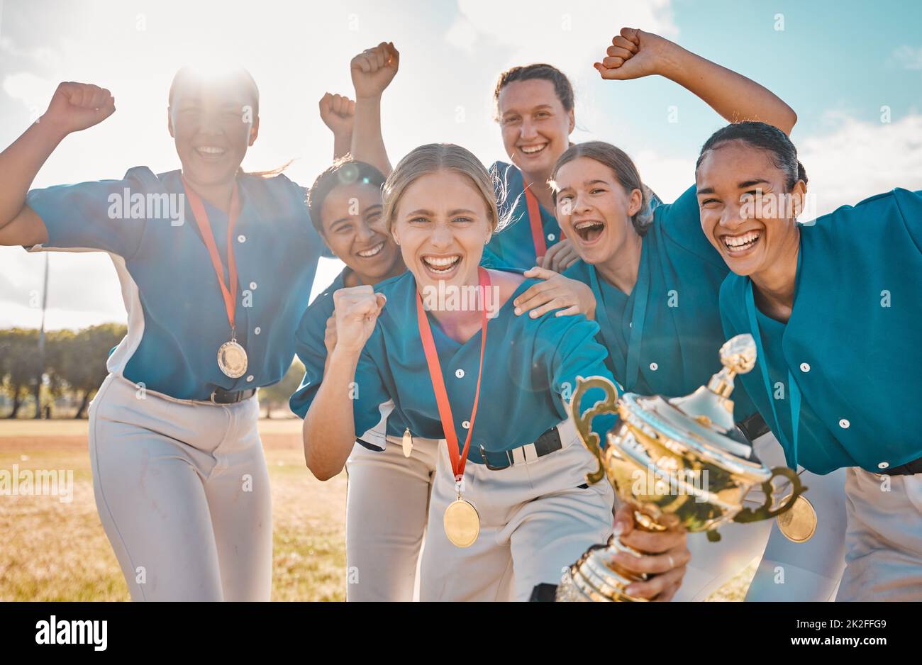 Ganador, éxito y trofeo con el equipo de béisbol femenino en celebración en el campo de parque para deportes, trabajo en equipo y campeón. Logro, motivación y feliz Foto de stock