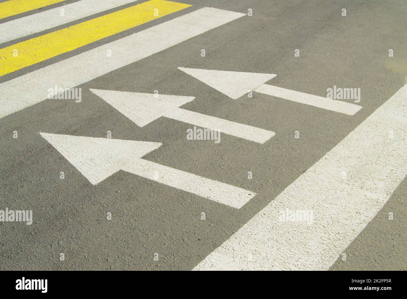 Carretera de asfalto con señal de flecha muestra la dirección del movimiento Foto de stock