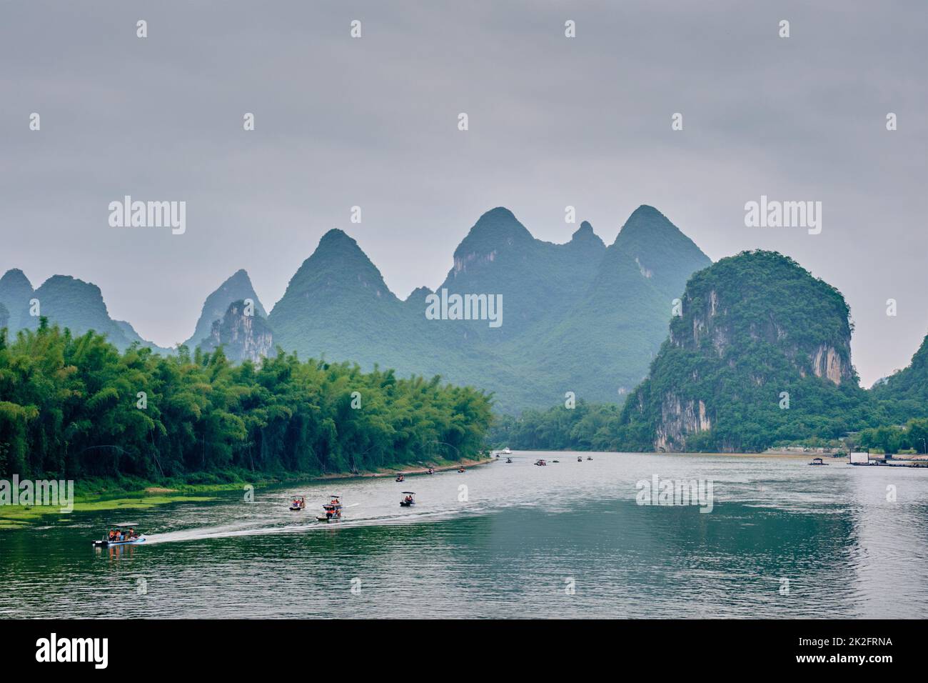 Los barcos turísticos en río Li, con las montañas al fondo carst Foto de stock