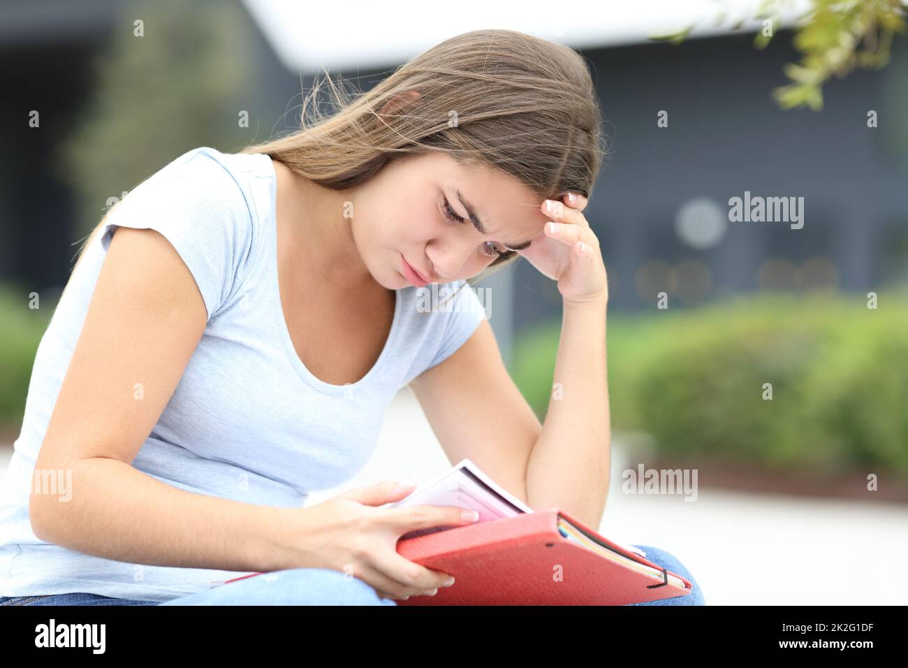 Estudiante concentrado memorizando notas en la calle Foto de stock