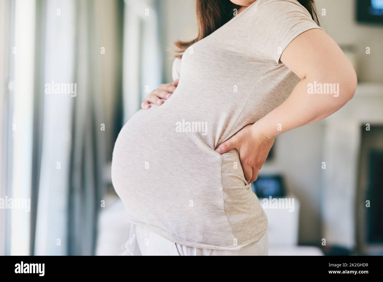 Todavía es tan surrealista. Disparo recortado de una mujer joven posando con su vientre embarazada. Foto de stock