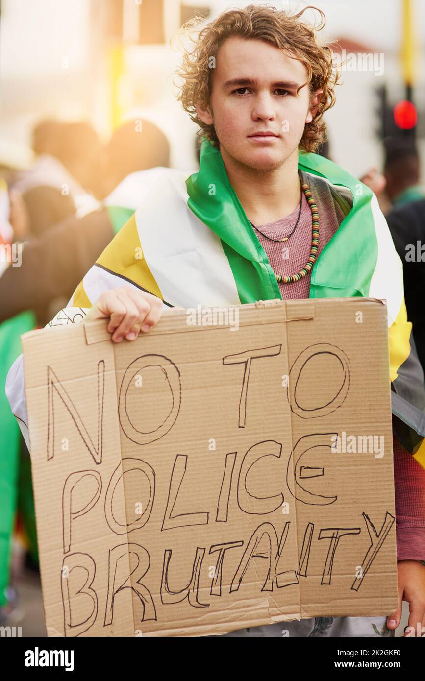 Tuvimos suficiente. Retrato de un joven manifestante con un signo de brutalidad antipolicial en una manifestación. Foto de stock