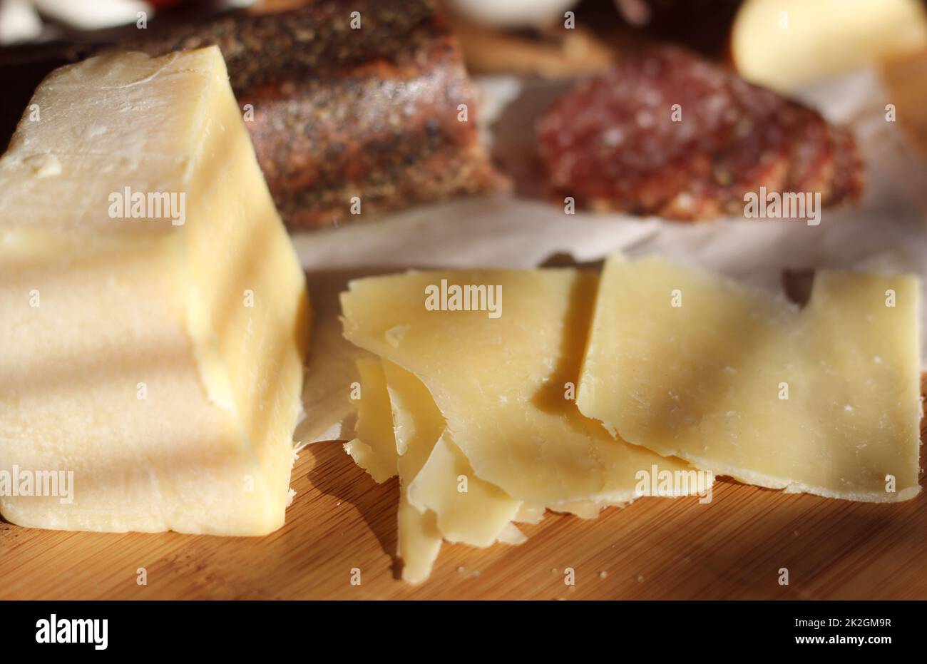 Salami de Peppercorn en bandeja con queso inglés e irlandés, manzanas en rodajas y especias en