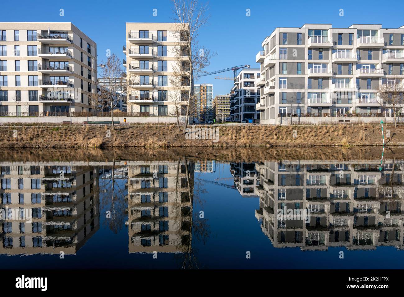 Modernos edificios de apartamentos en Berlín, Alemania, que se reflejan en un pequeño canal Foto de stock