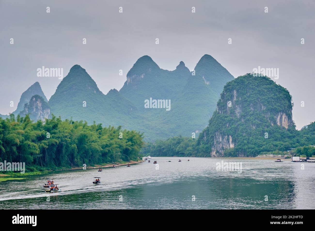 Los barcos turísticos en río Li, con las montañas al fondo carst Foto de stock