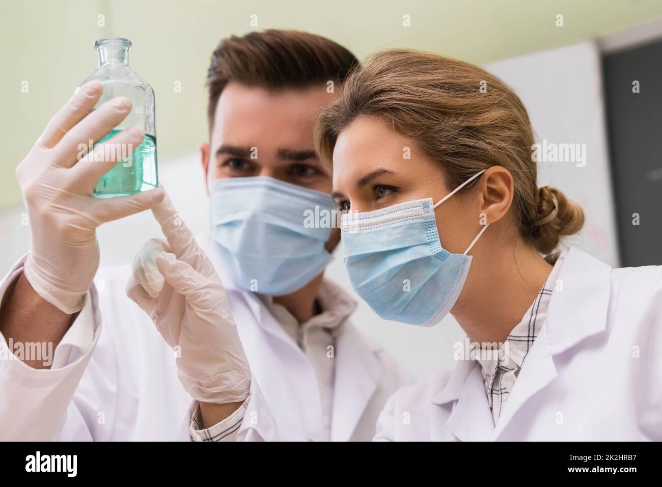 Científicos colegas están trabajando con reactivos químicos en un laboratorio durante la investigación Foto de stock