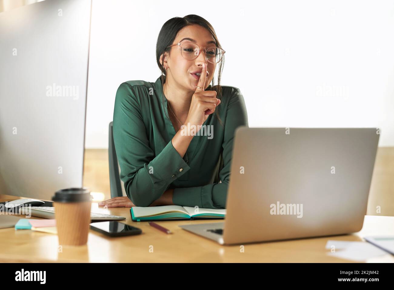 Guarde esa información a usted mismo. Fotografía de una joven empresaria que utiliza su ordenador portátil para organizar una videoconferencia en el trabajo. Foto de stock