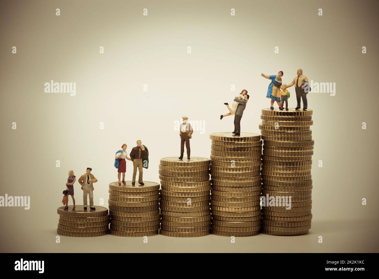 Concepto de escala social de varias personas en diferentes posiciones sobre pilas de monedas. Foto de stock
