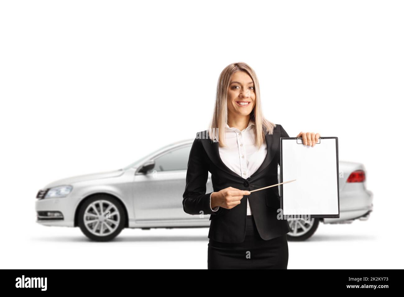 Mujer de negocios presentando un documento con un portapapeles delante de un coche plateado aislado sobre fondo blanco Foto de stock