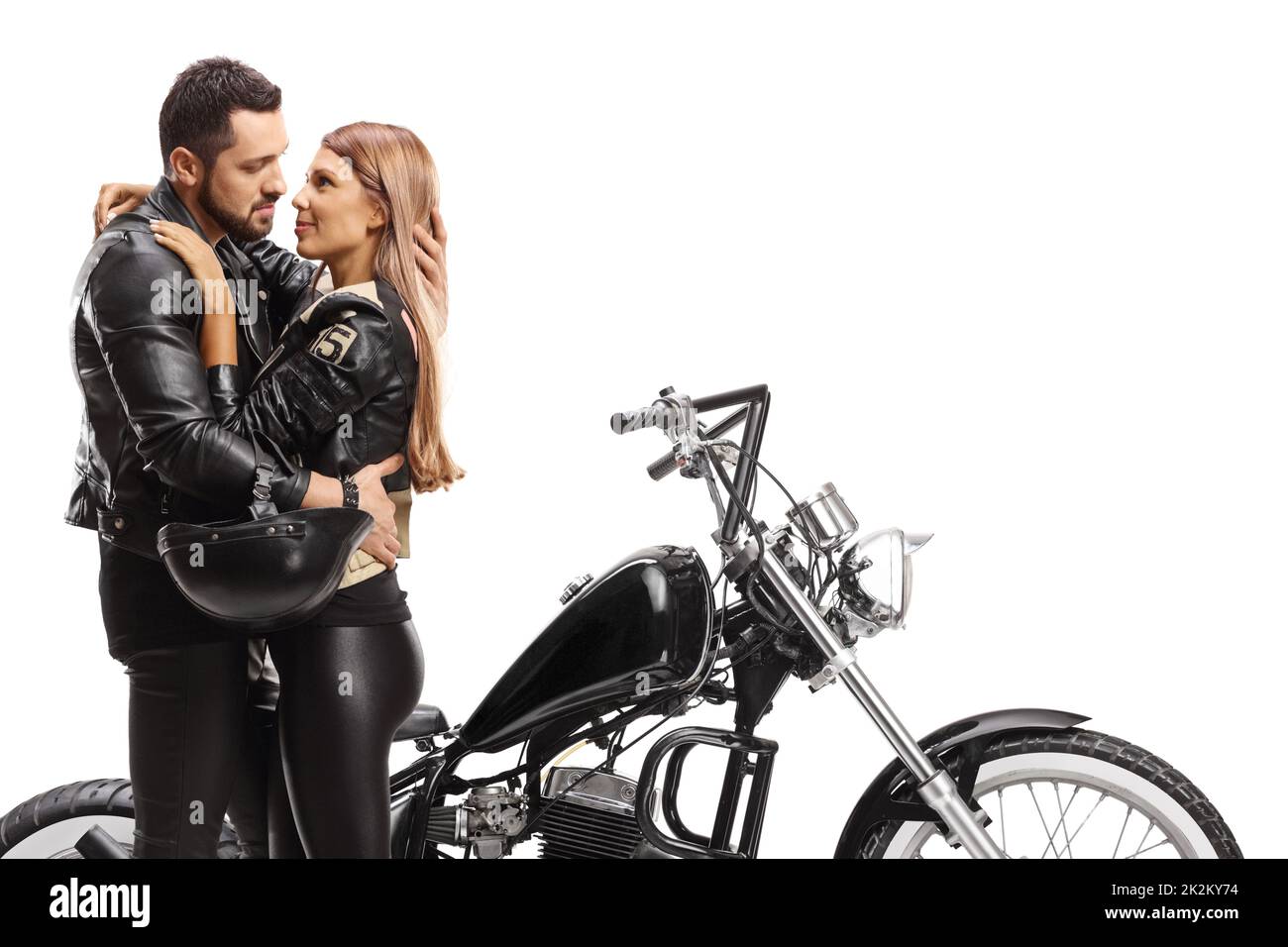 Hombre y mujer en el abrazo delante de una moto picadora aisladas sobre fondo blanco Foto de stock