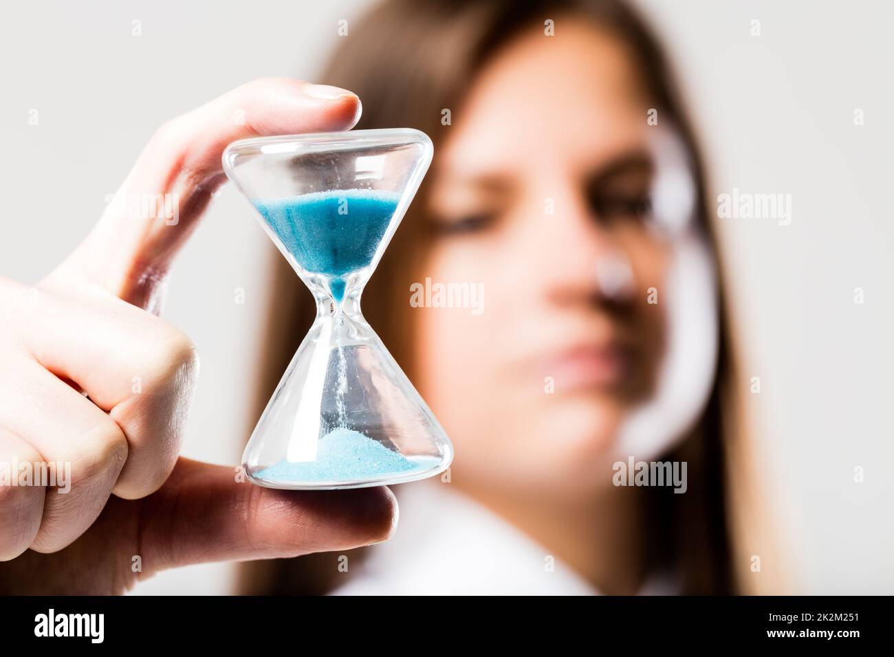 reloj de arena sostenido por una mujer preocupada Foto de stock