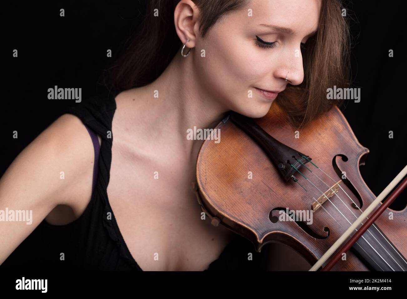 hermosa mujer tocando retrato de estudio de violín sobre negro Foto de stock