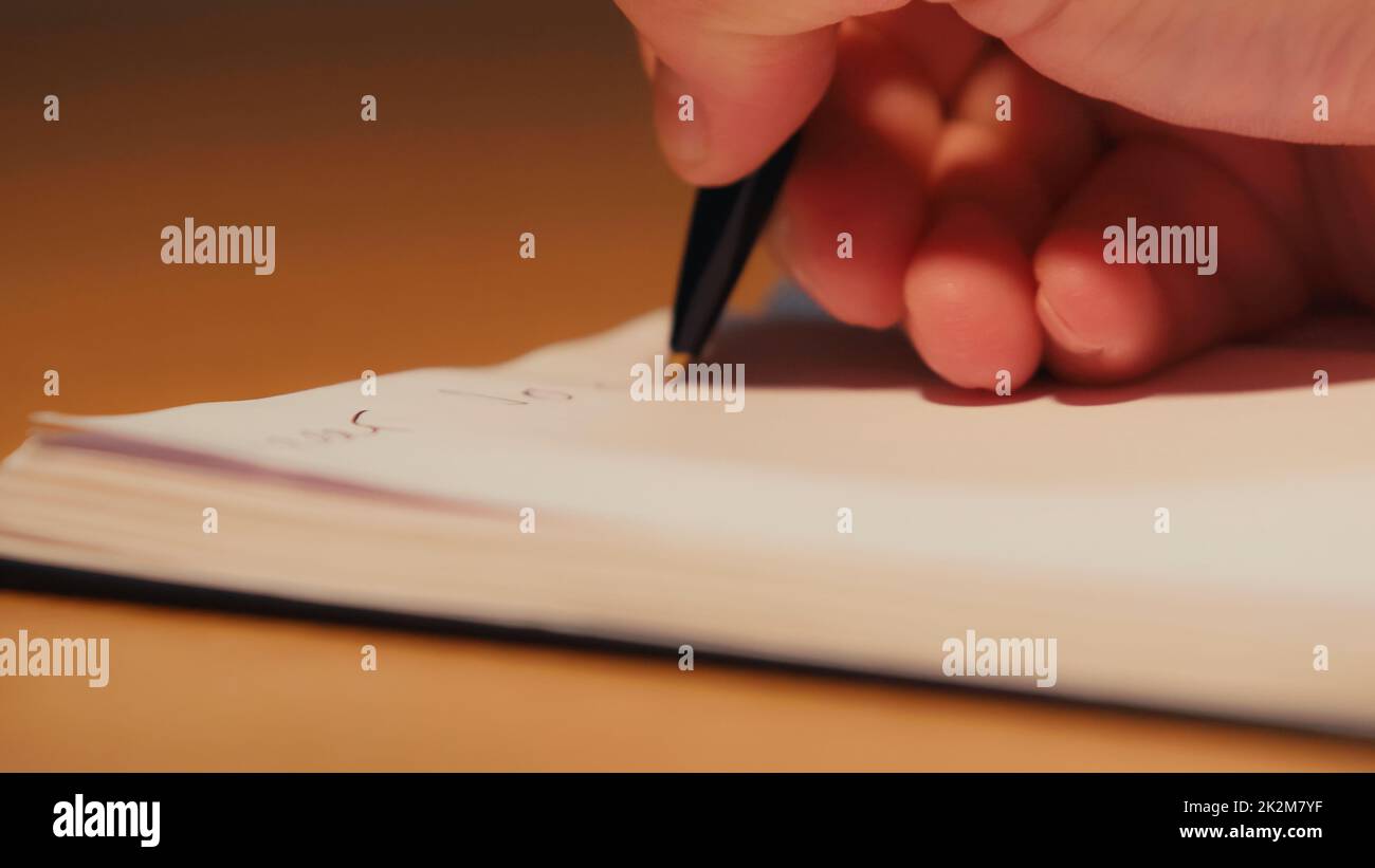 vista recortada del hombre sosteniendo el lápiz mientras escribía en el bloc de notas, imagen de stock Foto de stock