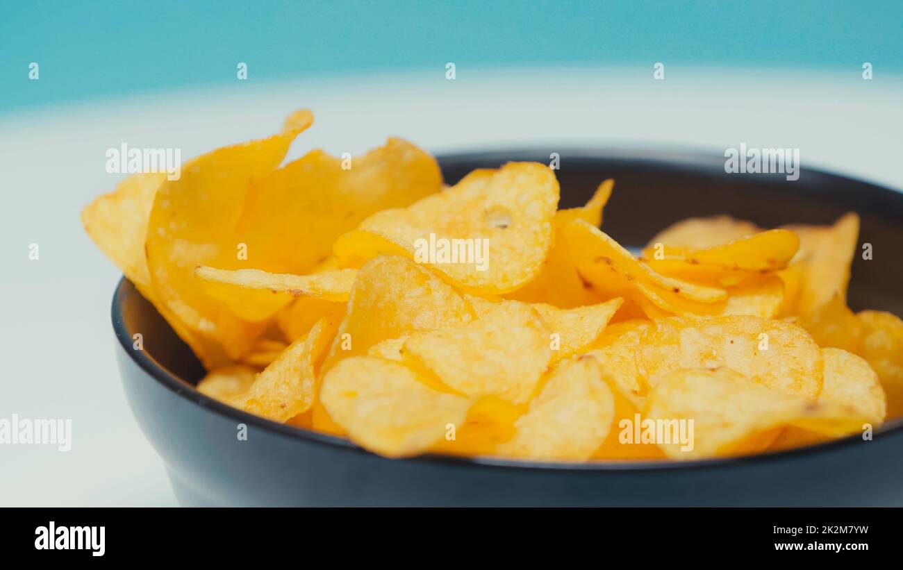 primer plano de las patatas fritas crujientes y onduladas en un recipiente en azul, imagen de archivo Foto de stock