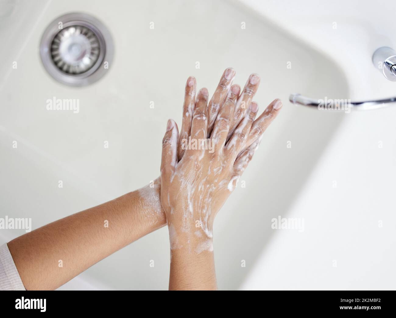 Lávese bien las manos. Disparo de una persona irreconocible lavándose las manos en casa. Foto de stock