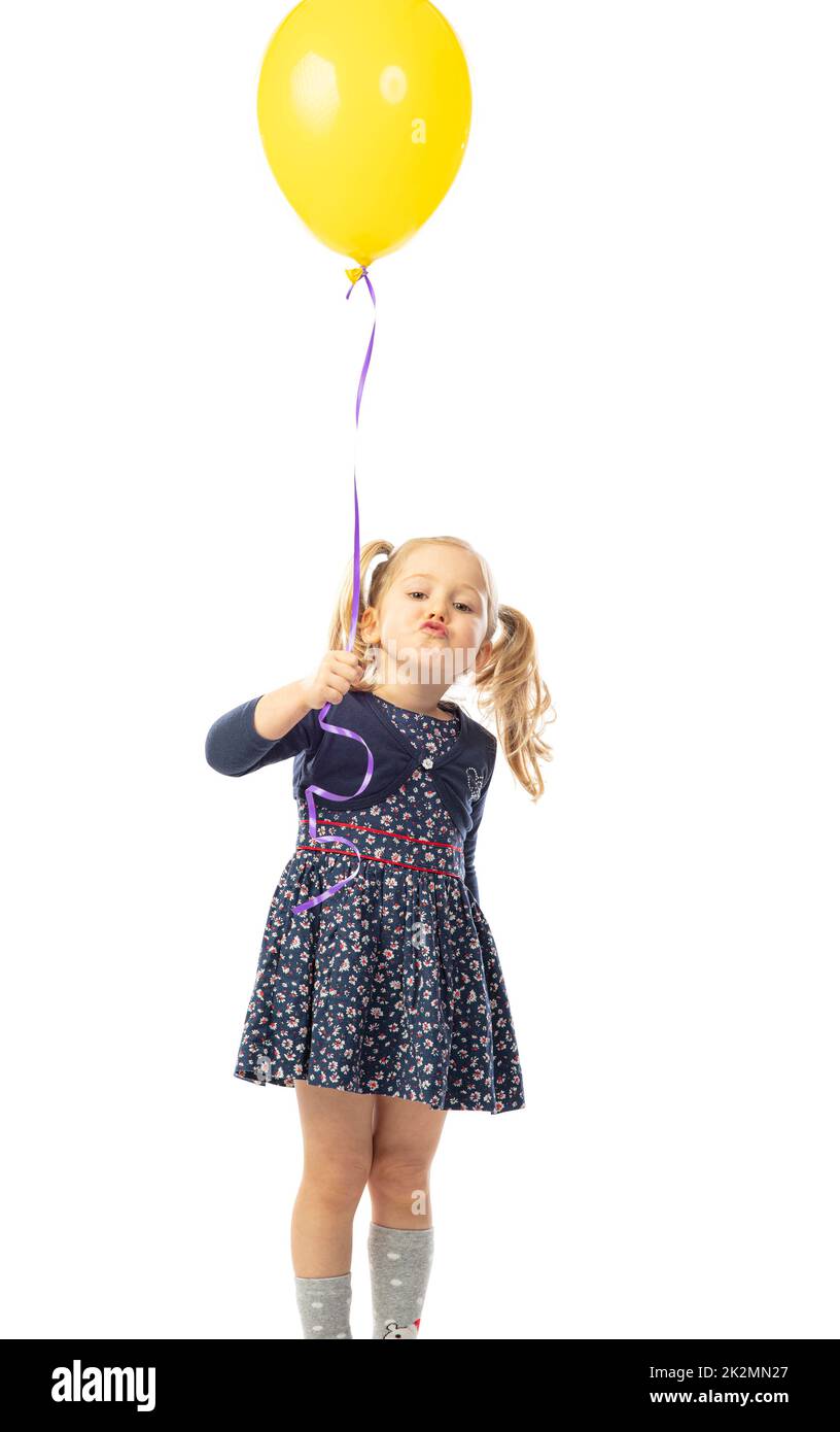 niña rubia con cola de cerdo sosteniendo un globo. aislada sobre blanco. Foto de stock