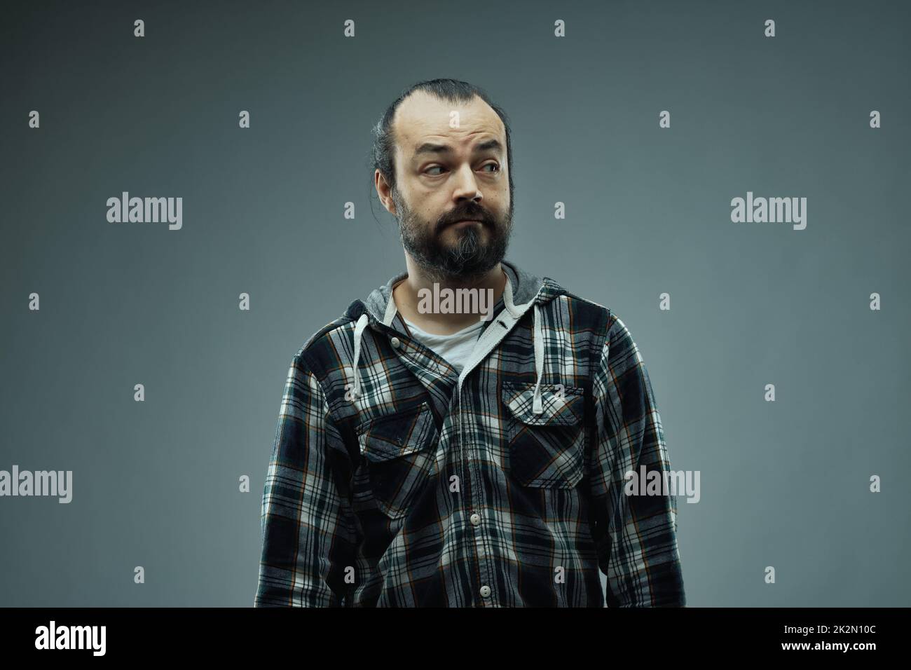 Retrato de estudio de un hombre con una expresión facial sospechosa Foto de stock