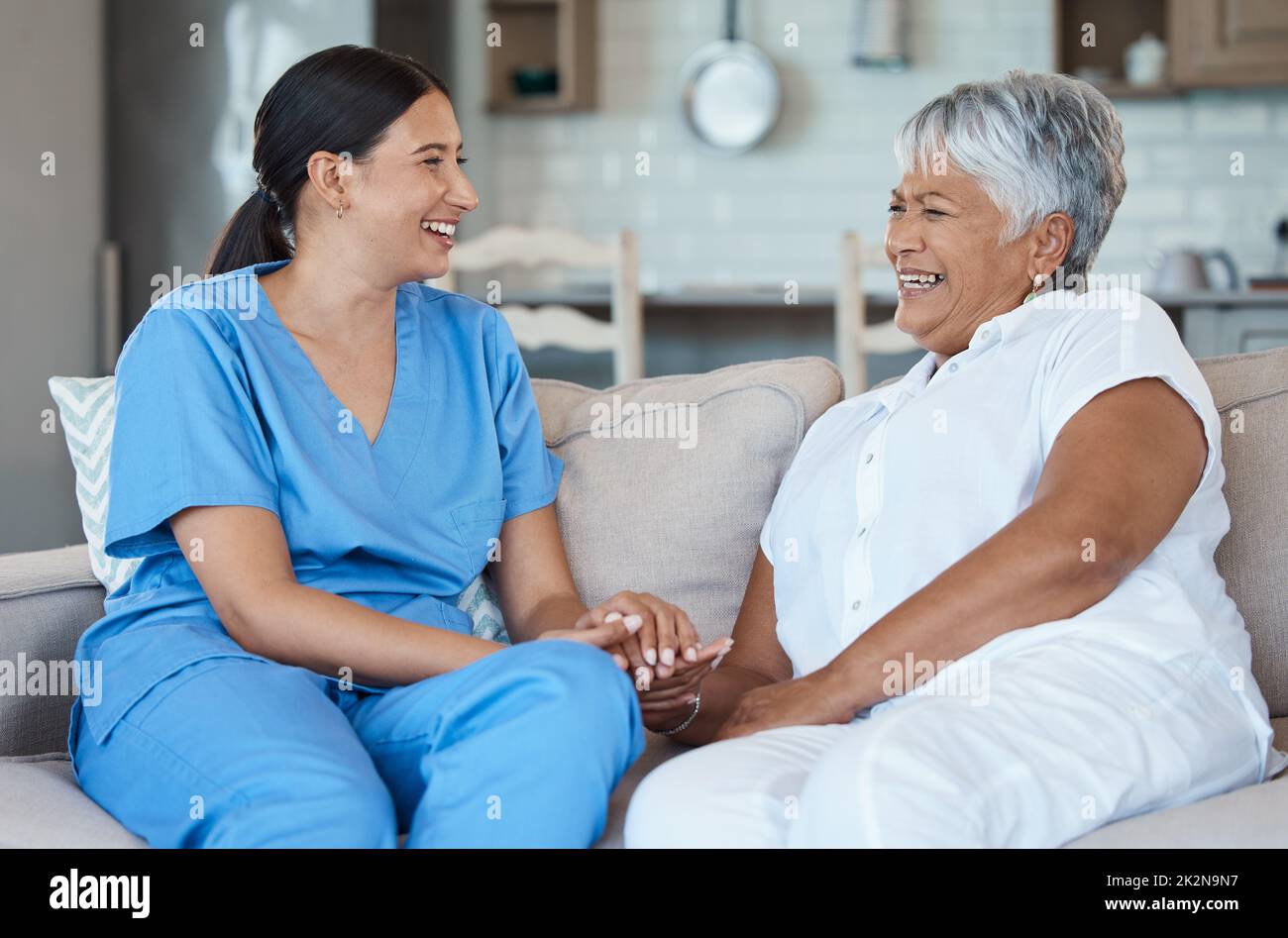 Pasar un poco de una vez con sus pacientes. Retrato recortado de una atractiva mujer mayor y su enfermera femenina en el hogar de la vejez. Foto de stock