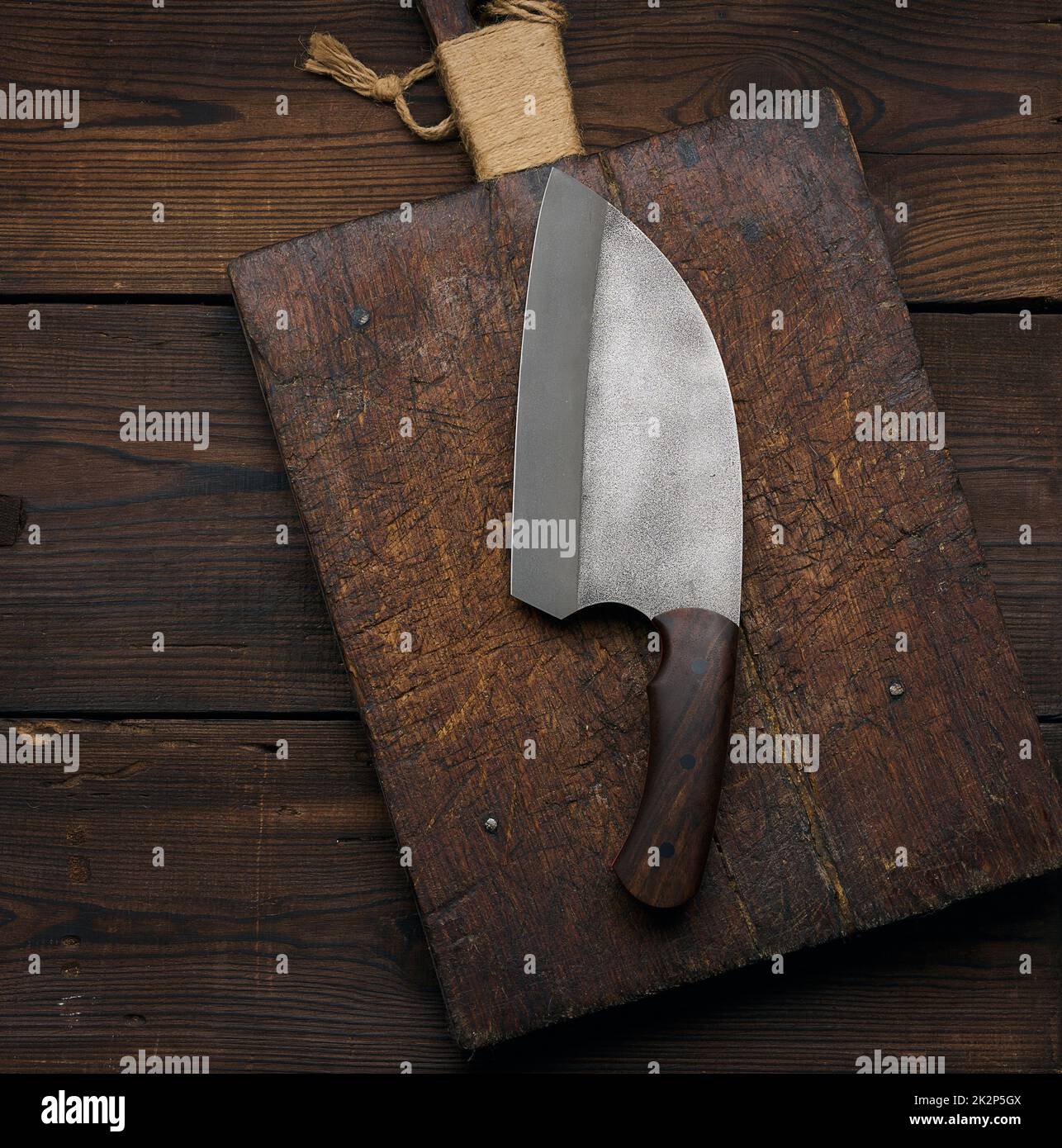 Cuchillo de cocina grande sobre una tabla de cortar de madera vacía, vista superior Foto de stock