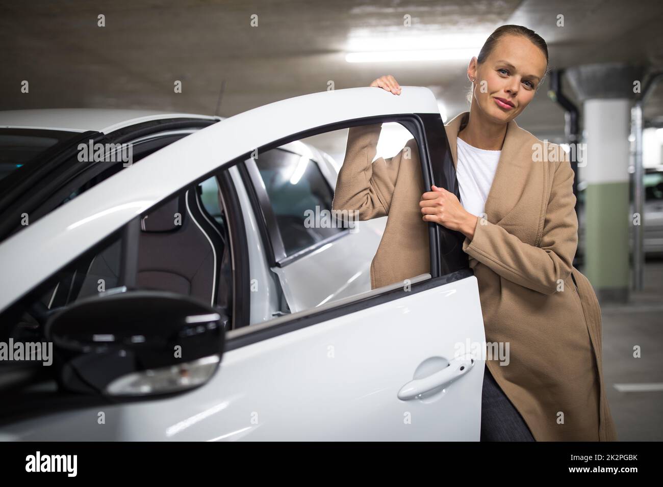 Aparcamiento/garaje subterráneo (imagen poco profunda en tonos de color DOF) - mujer joven con su coche en el aparcamiento subterráneo Foto de stock