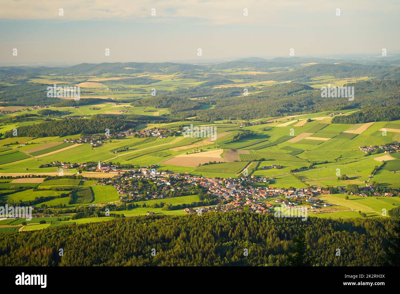 Vista desde el monte Hohenbogen hasta Neukirchen Heiligblut, una pequeña ciudad en el bosque bávaro. Foto de stock
