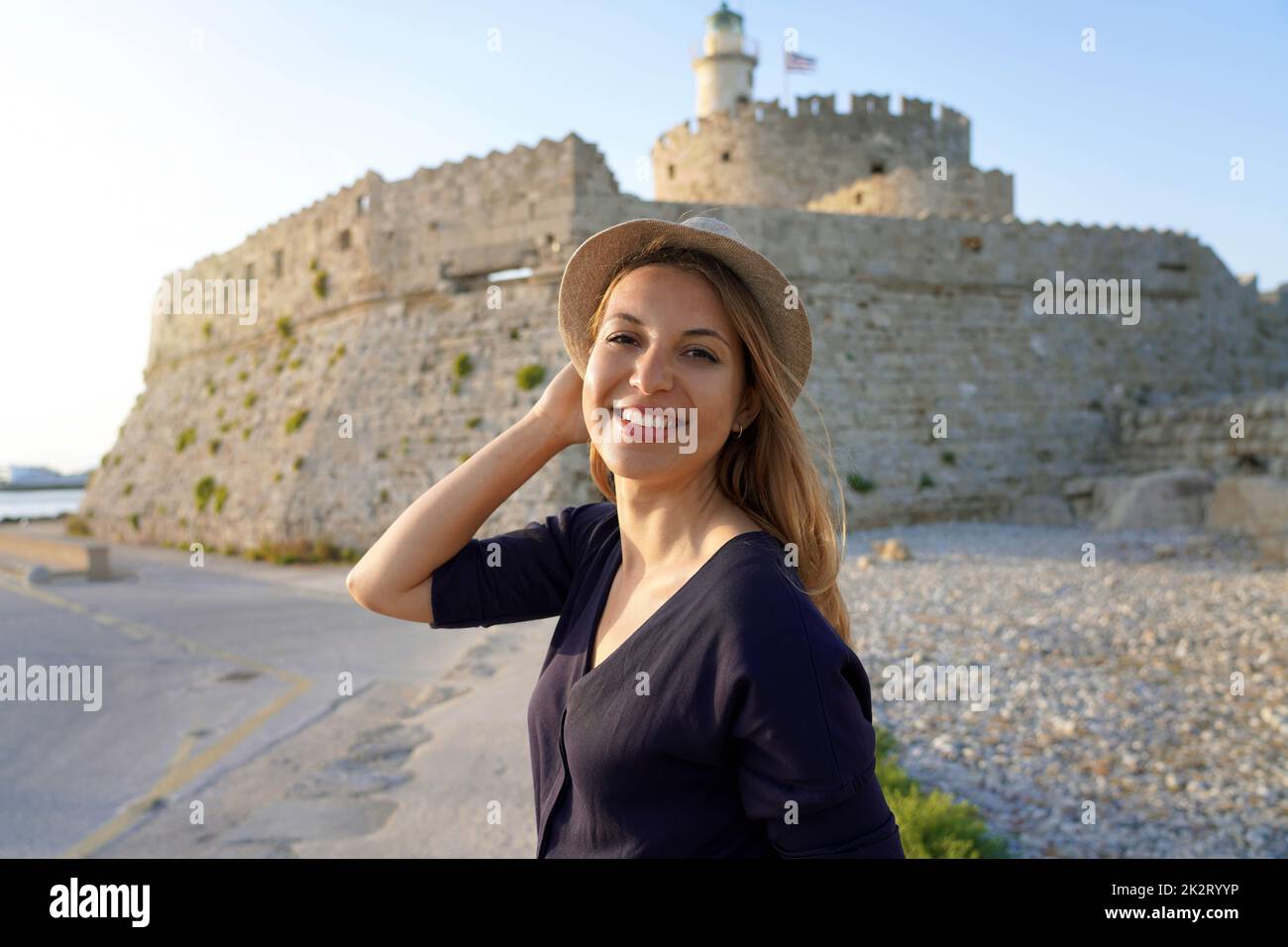 Retrato de una joven turista en la isla de Rodas con la Torre y el Fuerte de San Nicolás, Grecia Foto de stock