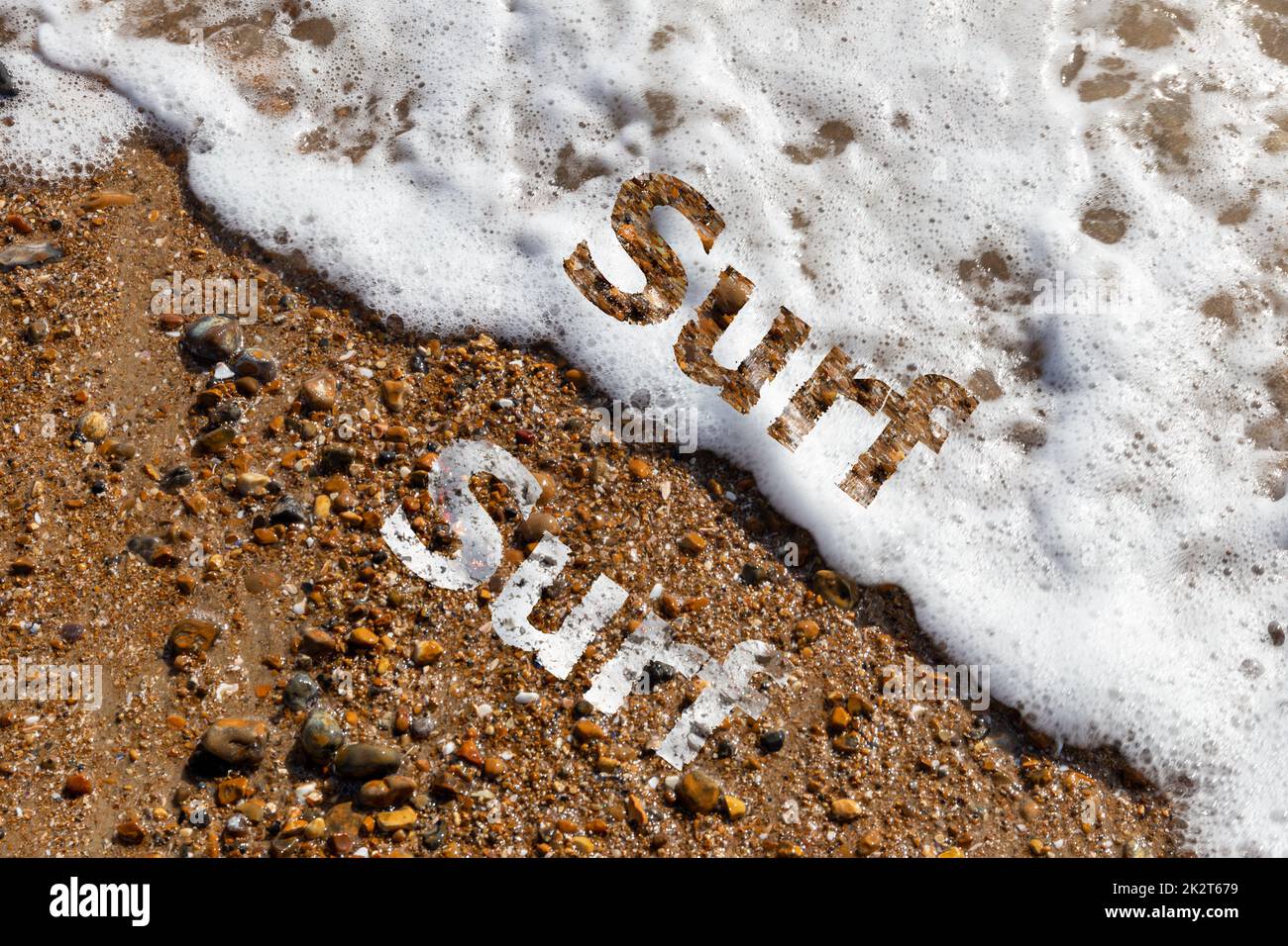 Texto de surf cortado en la playa de guijarros y olas rompiendo Foto de stock