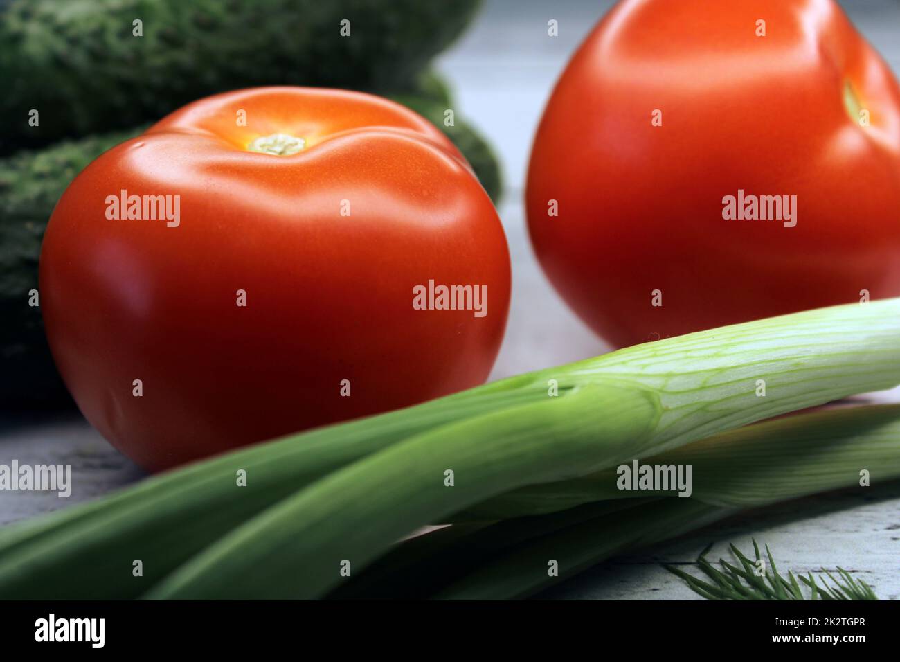 Pepinos, tomates, cebollas verdes de primer plano. El concepto de vegetarianismo, alimentación saludable. Foto de stock
