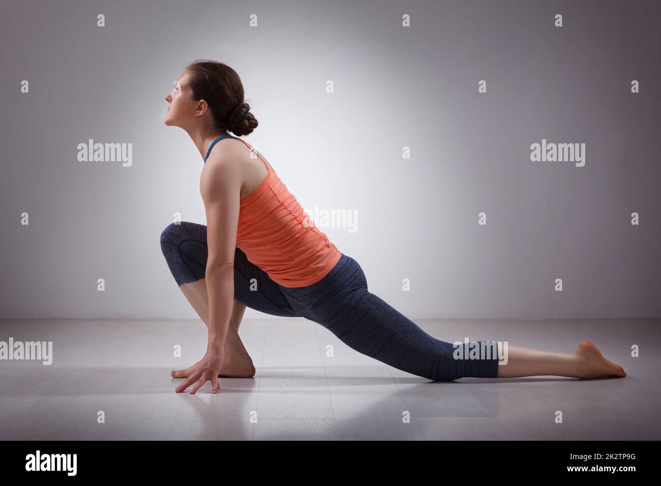 Mujer en forma de yogini practica yoga asana Anjaneyasana Foto de stock