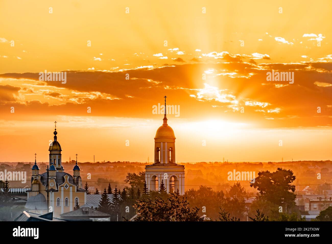 Cúpulas de oro con cruces ortodoxas en la iglesia.Temple o catedral en el fondo de una puesta de sol de la tarde con un cielo de oro. Una iglesia solitaria al anochecer con el atardecer nubarres.Golden Hour, horizonte, horizonte Foto de stock