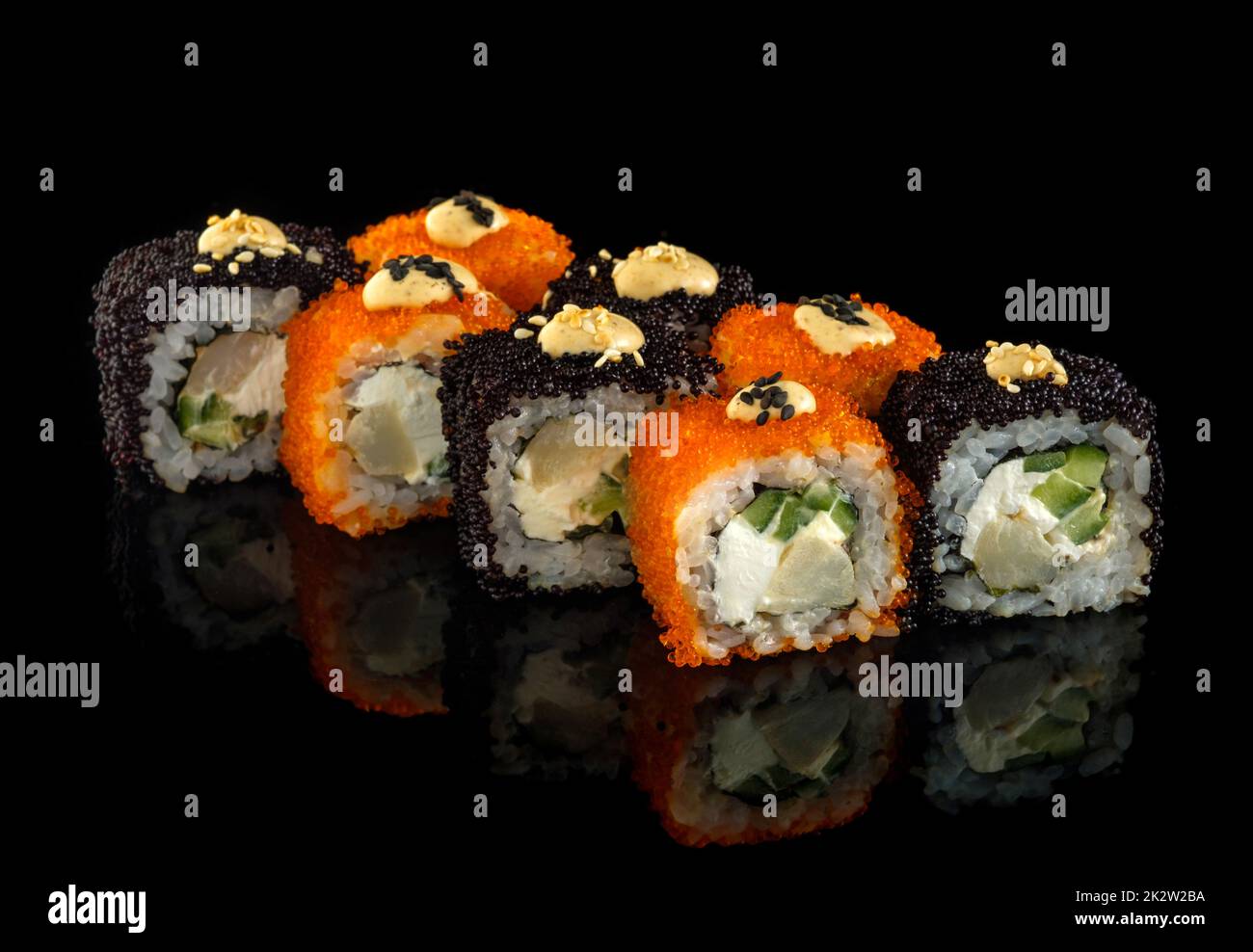 Rollo de sushi fijo. Cocina japonesa tradicional. Aislado sobre fondo negro Foto de stock