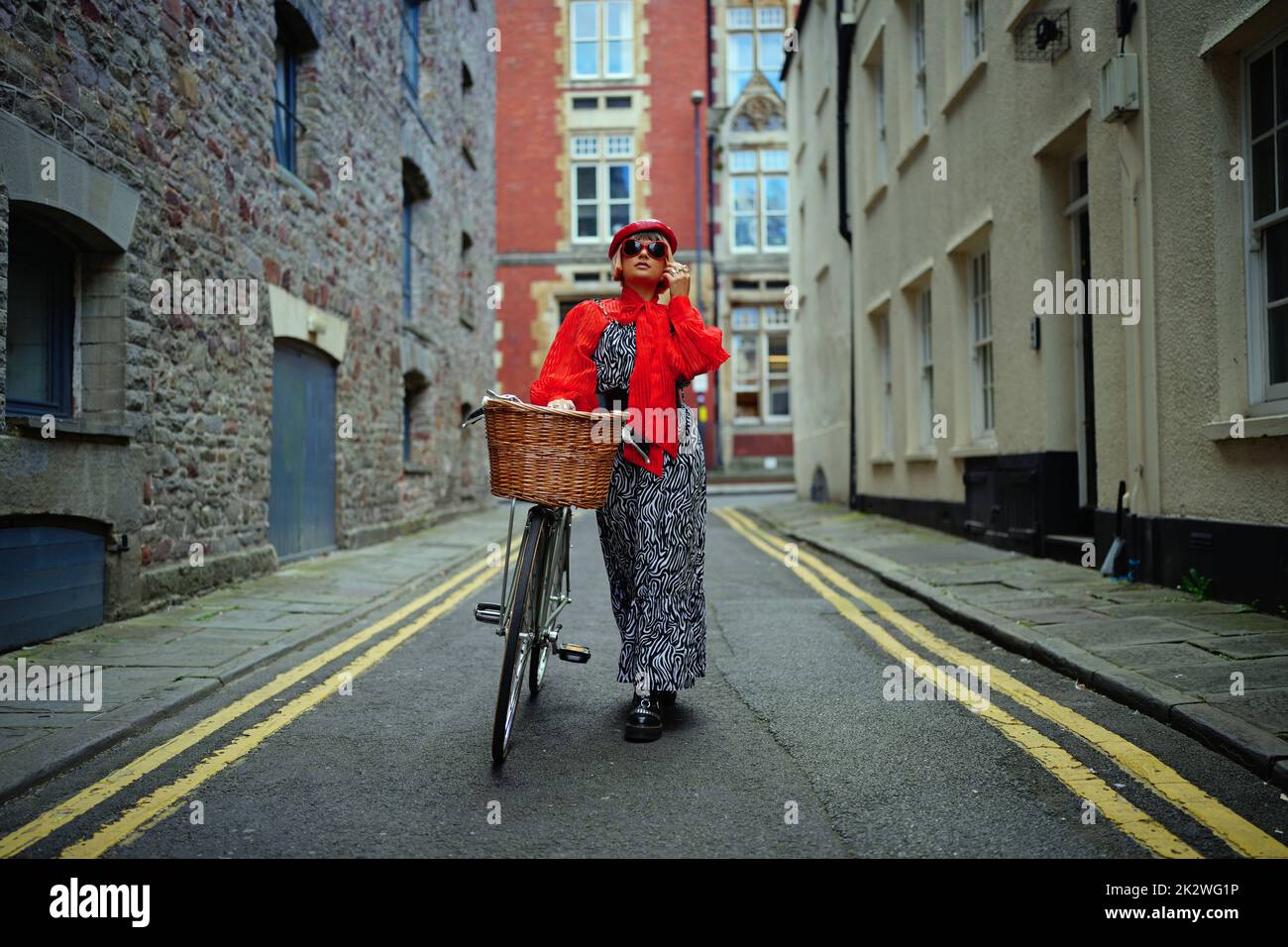 La estilista de moda sostenible Meg Cox lleva un conjunto completo de productos sostenibles de la cabeza a los pies, que incluye accesorios y su bicicleta, mientras modela en el centro de Bristol como parte de la primera semana de la moda sostenible del Reino Unido, que se celebra en todo el país. Fecha de la foto: Viernes 23 de septiembre de 2022. Foto de stock
