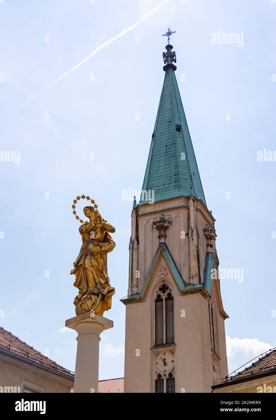 Una foto de la torre de la Catedral de Celje y la Columna de la Plaga. Foto de stock