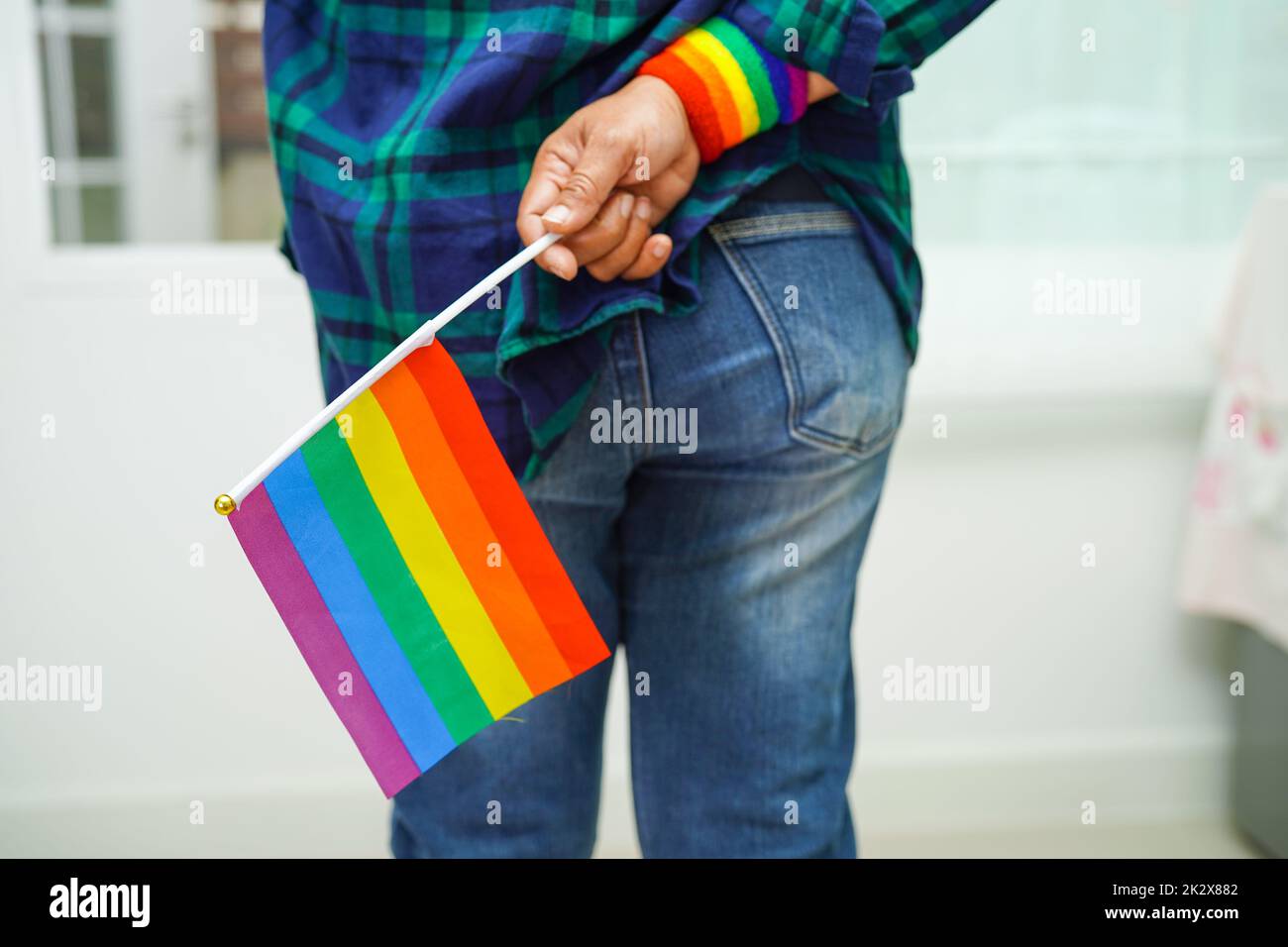 Mujer asiática con bandera arcoiris, derechos de símbolos LGBT e igualdad de género, mes del orgullo LGBT en junio. Foto de stock