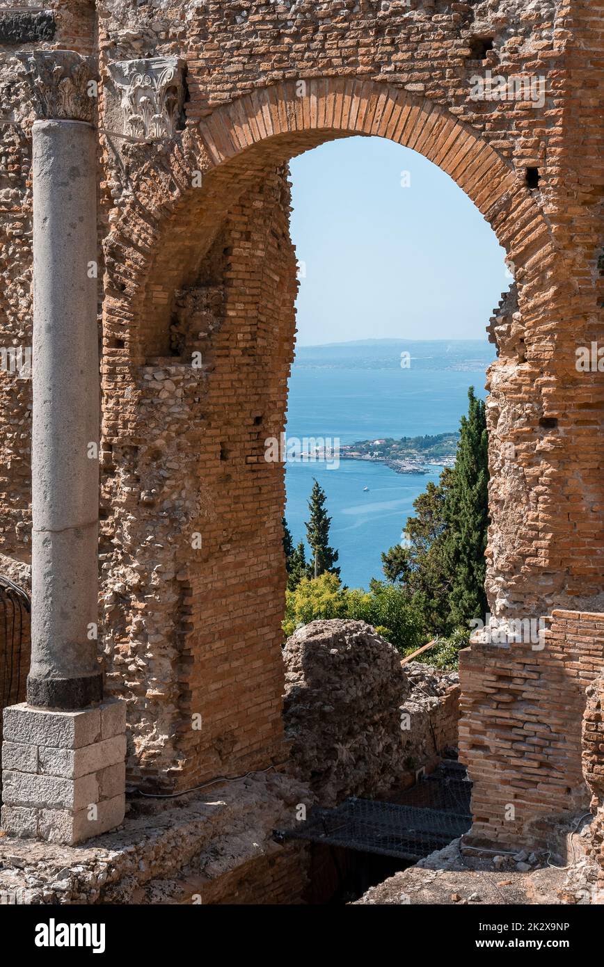Columna y arco en las antiguas ruinas del antiguo teatro griego con el mar en el fondo Foto de stock