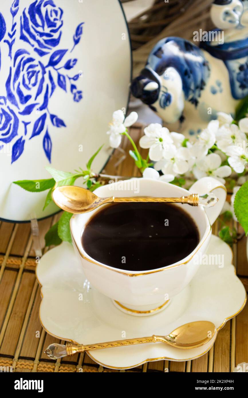 Taza de té aromático fresco en la mesa con fondo de flores de la naturaleza