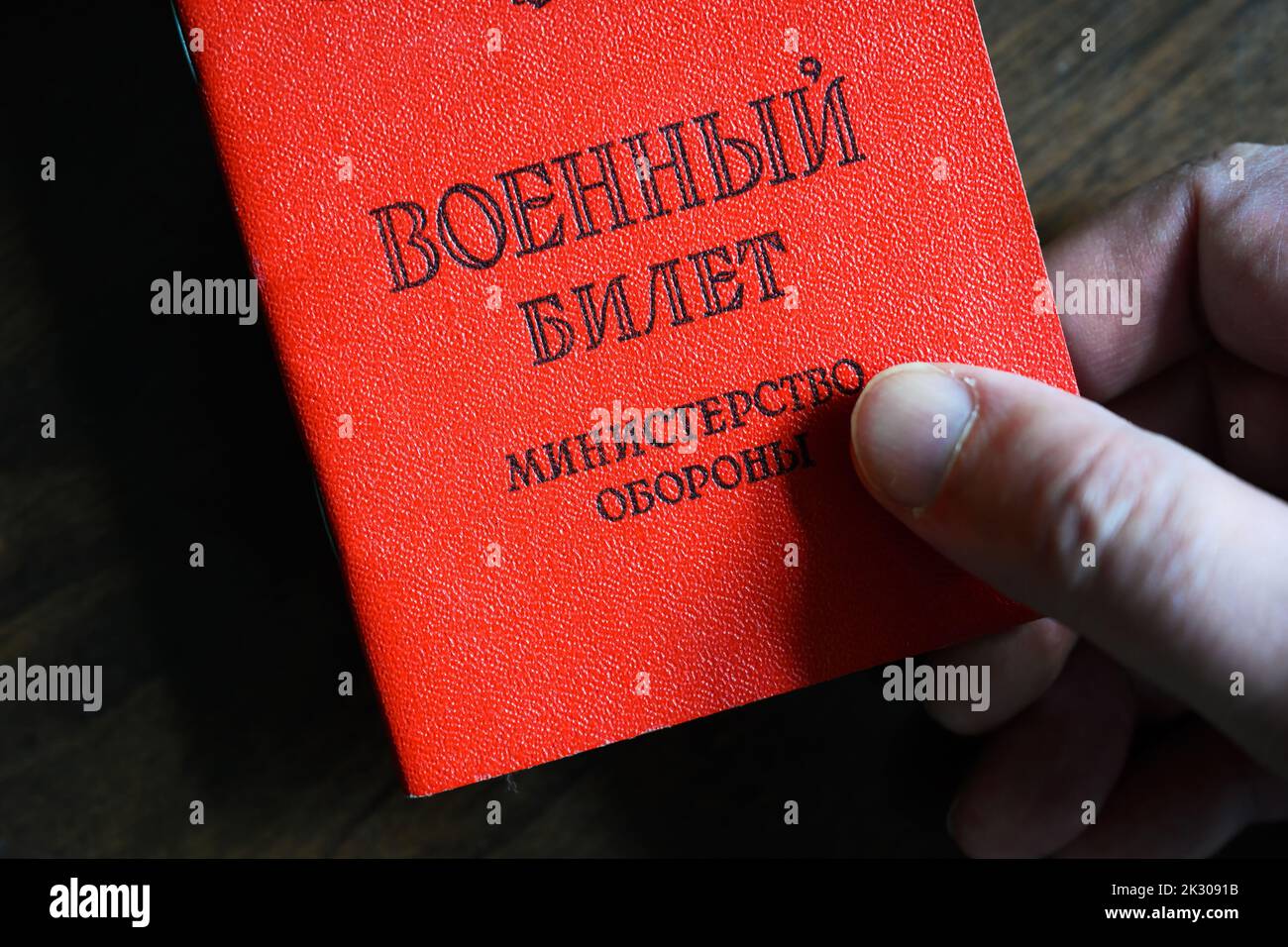 Certificado del militar ruso en la mano, vista superior. Concepto de movilización en Rusia, guerra en Ucrania, soldado, deber, reserva y ejército. Traducción: Foto de stock