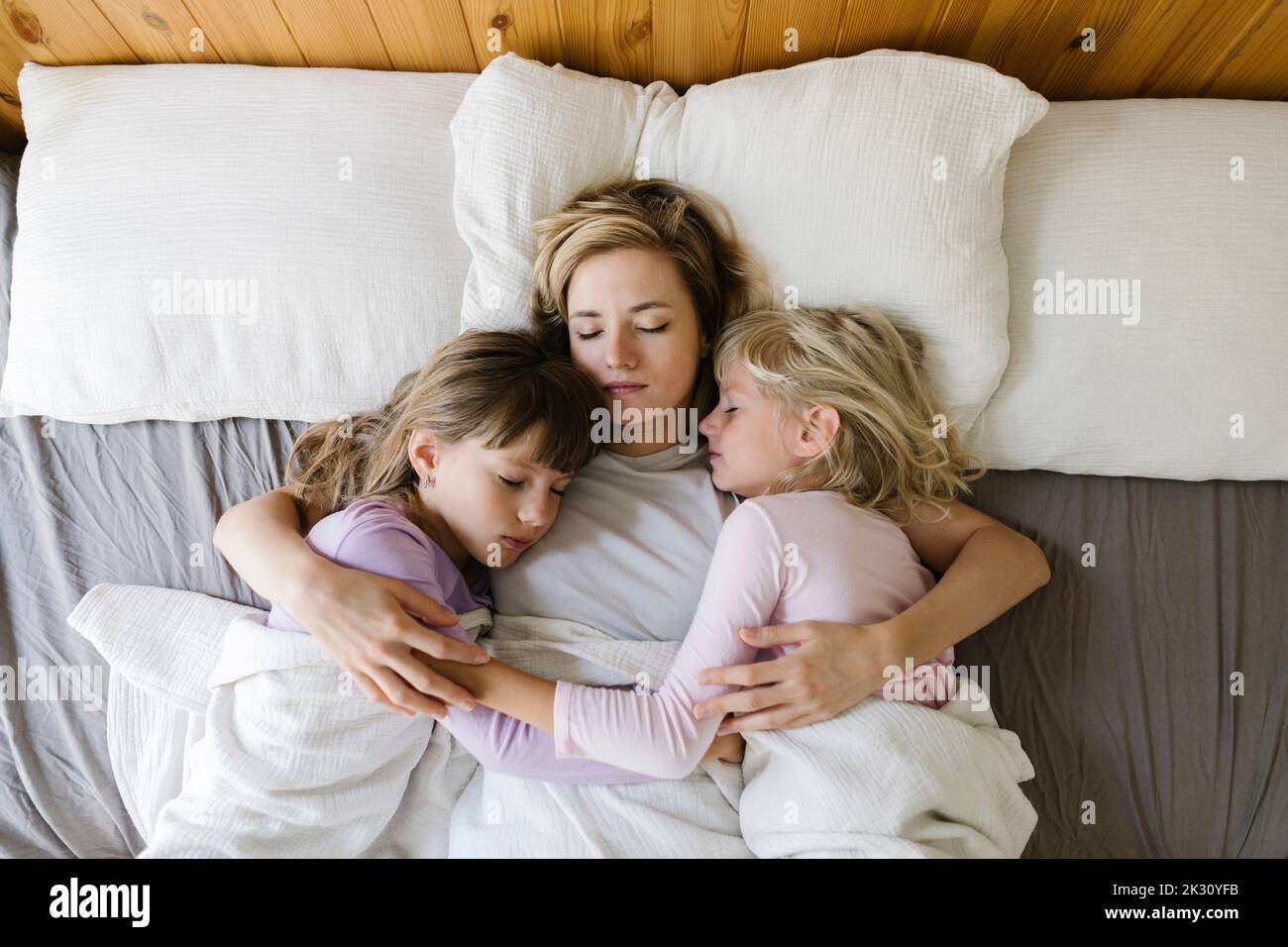 Madre durmiendo con sus hijas en cama fotografías e imágenes de alta ...